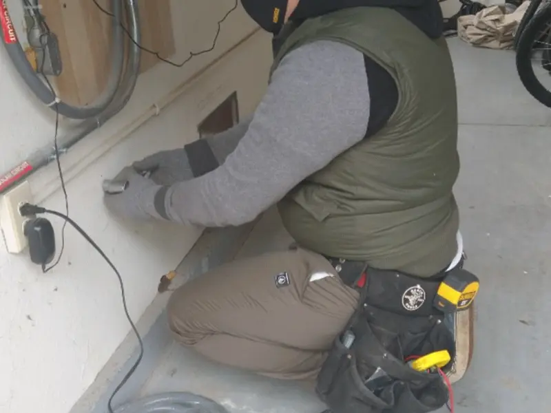 Electrician performing outlet wiring in a Casco garage